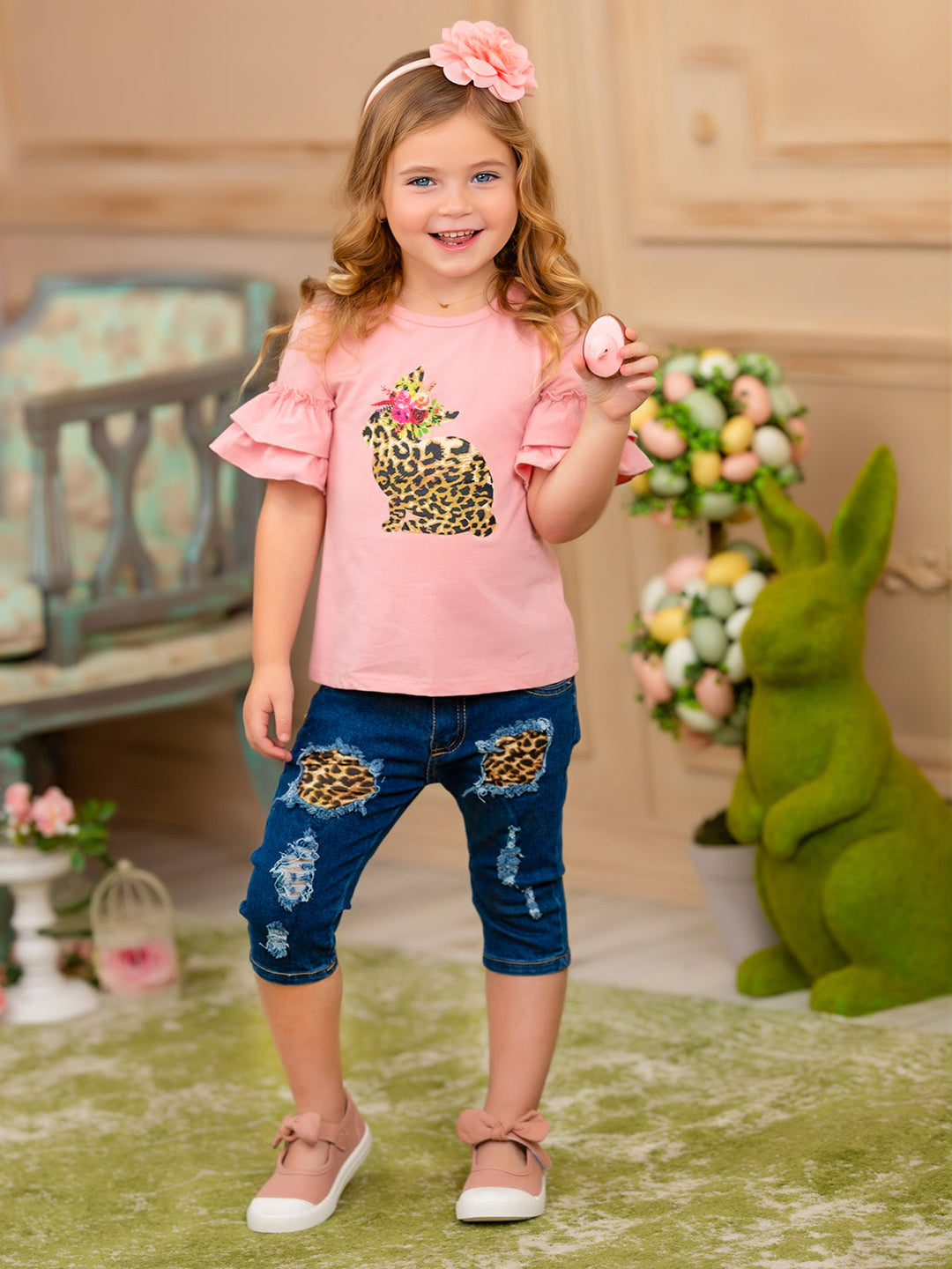 Girls Easter-themed set features a ruffled sleeve top with a leopard print bunny graphic and patched denim capris with a leopard print sash belt for 2T to 10Y toddlers and girls