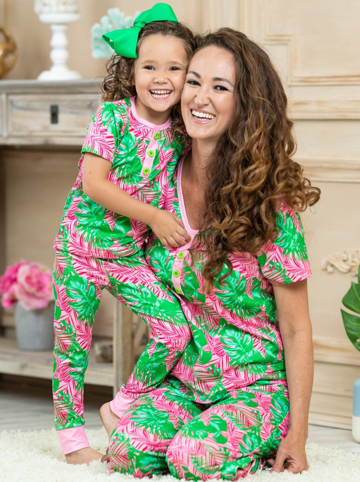 short leeved pink pajamas feature pink/green palm leaf prints, 3 front buttons, and pink cuffs on the kid version 